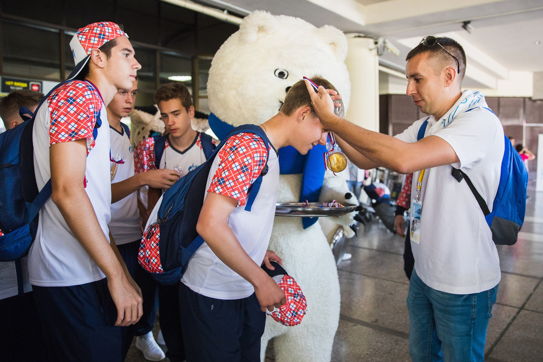 Каждую делегацию в аэропорту встречают кураторы и символы Олимпиады. И каждый уже победитель, потому что каждому вручается медаль