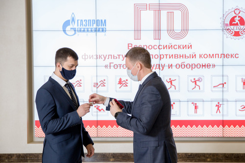 Евгений Гусев, заместитель генерального директора по управлению персоналом ООО «Газпром трансгаз Ухта», награждает Никиту Лазеева, инженера-программиста Службы информационно-управляющих систем